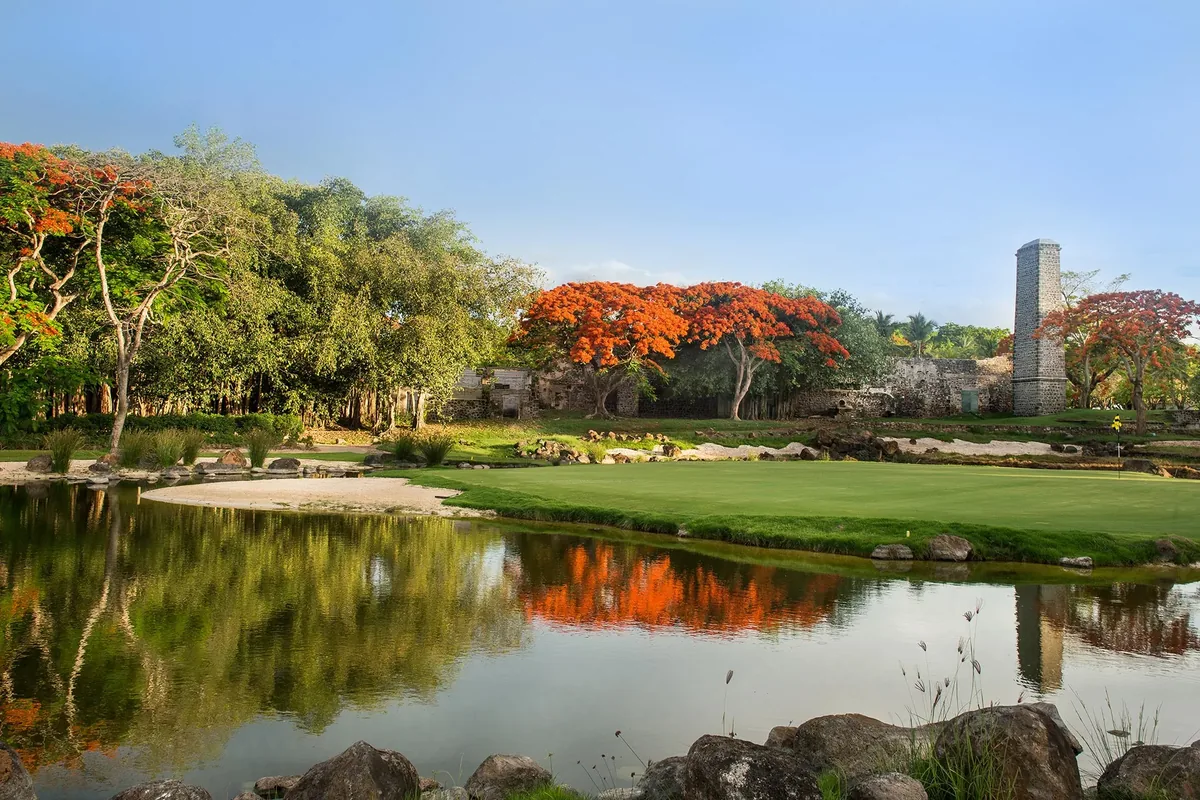 Historic sugar-mill chimney beside a green at Mont Choisy Le Golf
